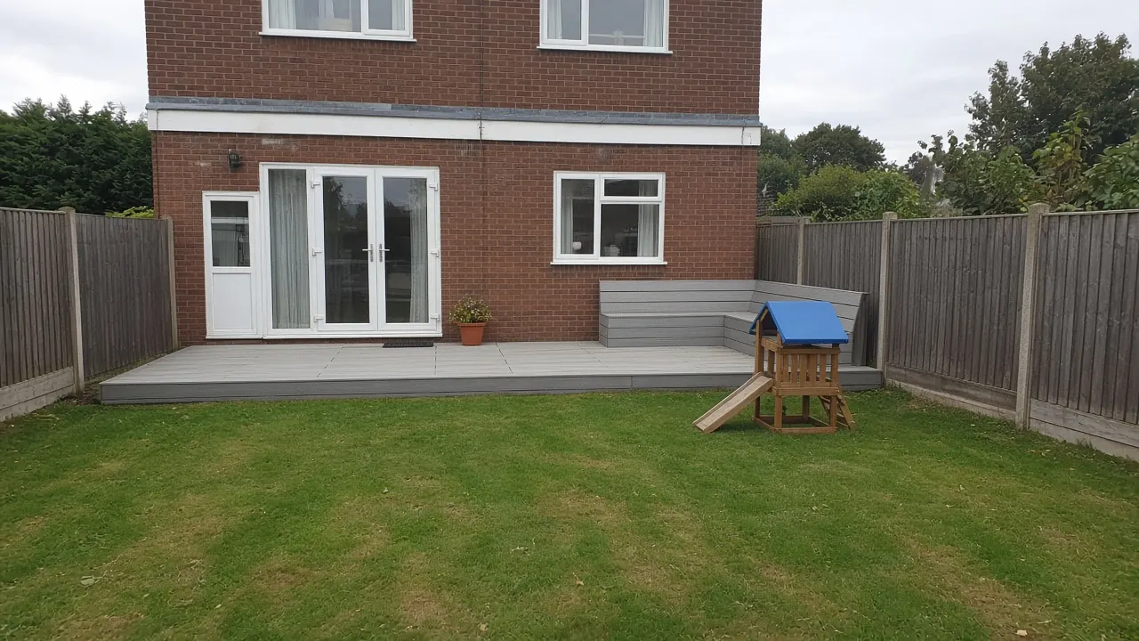 Example image: low grey composite deck with a built-in bench behind a semi in Harrowgate Hill